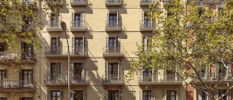 A multi-story building with balconies, storefronts, and signage for businesses.