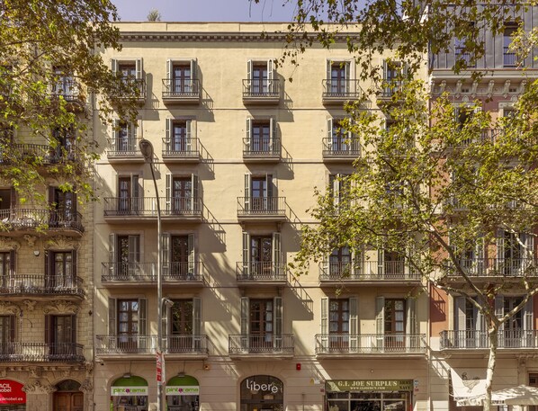 A multi-story building with balconies, storefronts, and signage for businesses.