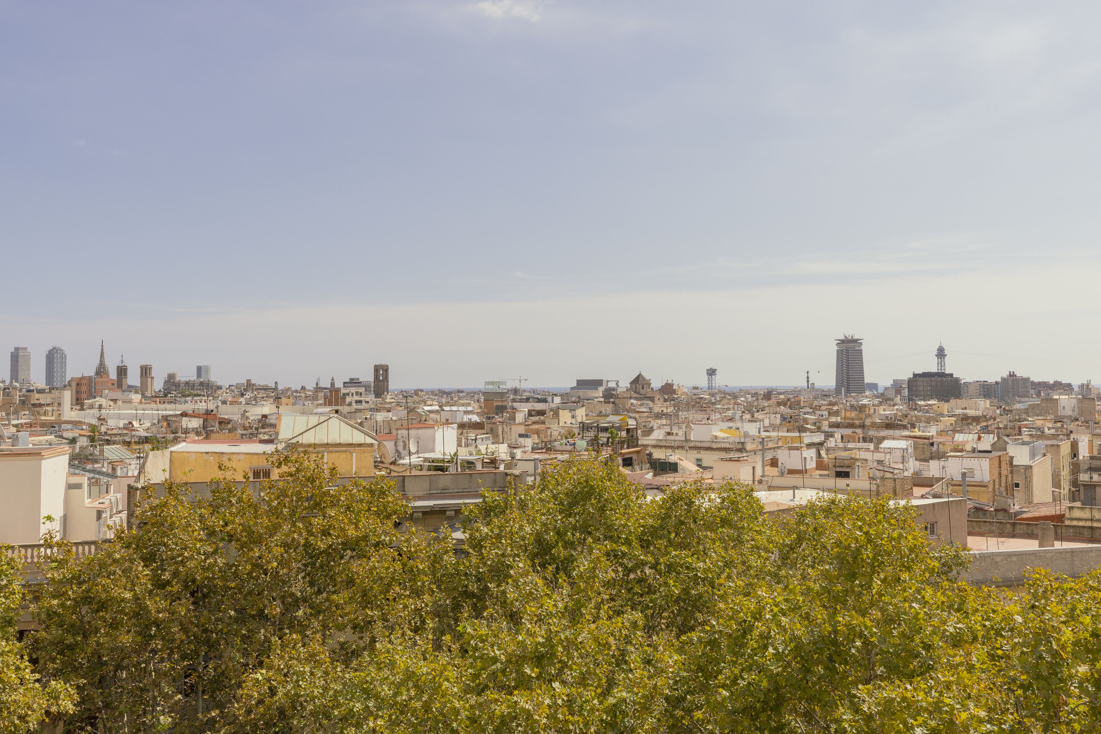 Un paysage urbain mêlant bâtiments modernes et bâtiments plus anciens, avec un beffroi imposant et un ciel dégagé.