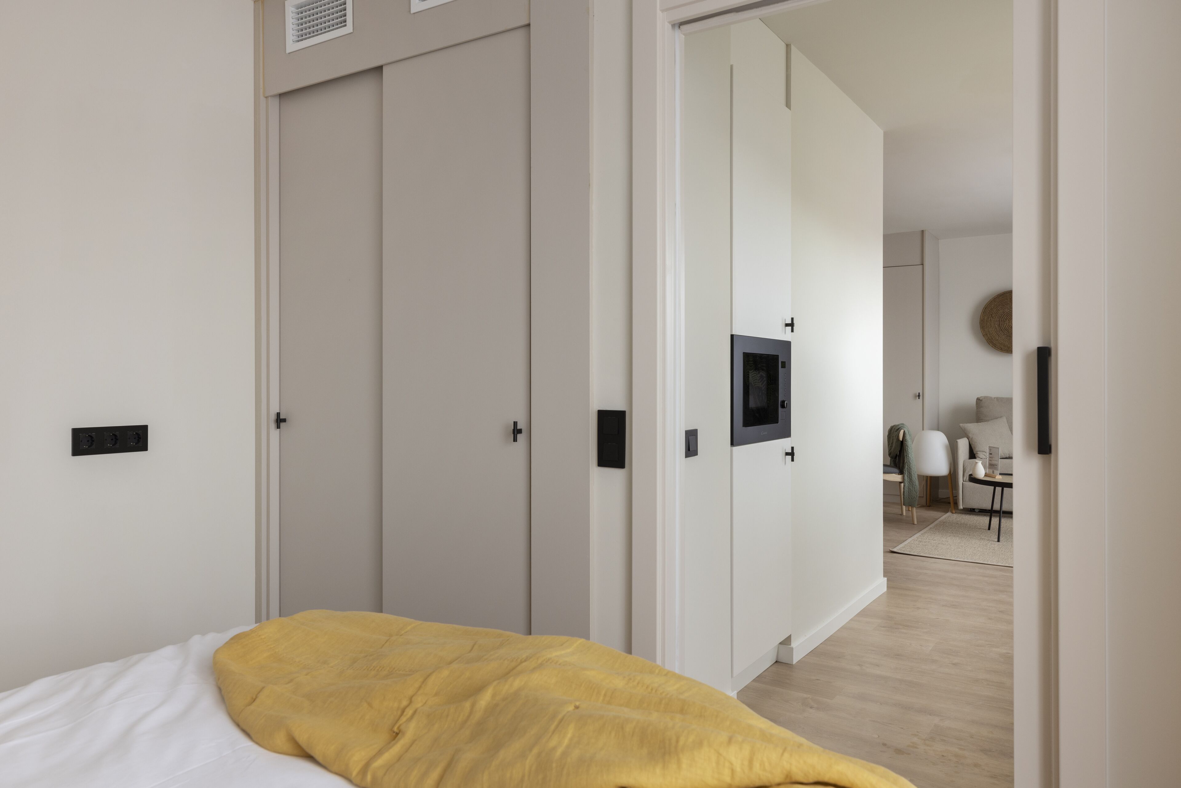 A bedroom with a bed, a wardrobe, and a television.
