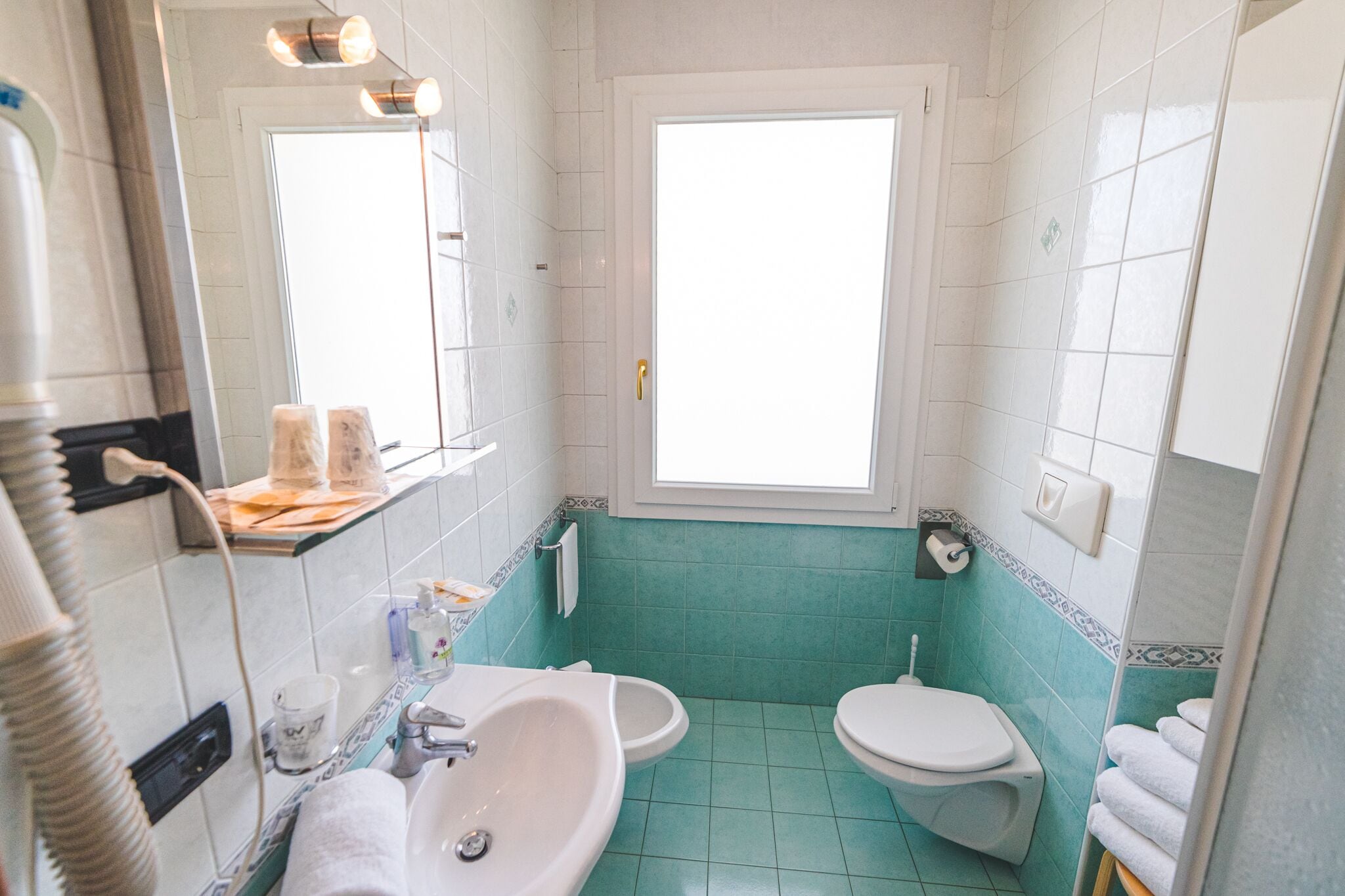 Een badkamer met een wastafel, toilet en spiegel.