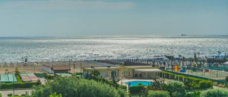 Un hotel frente al mar con piscina, acceso a la playa y vistas al océano.