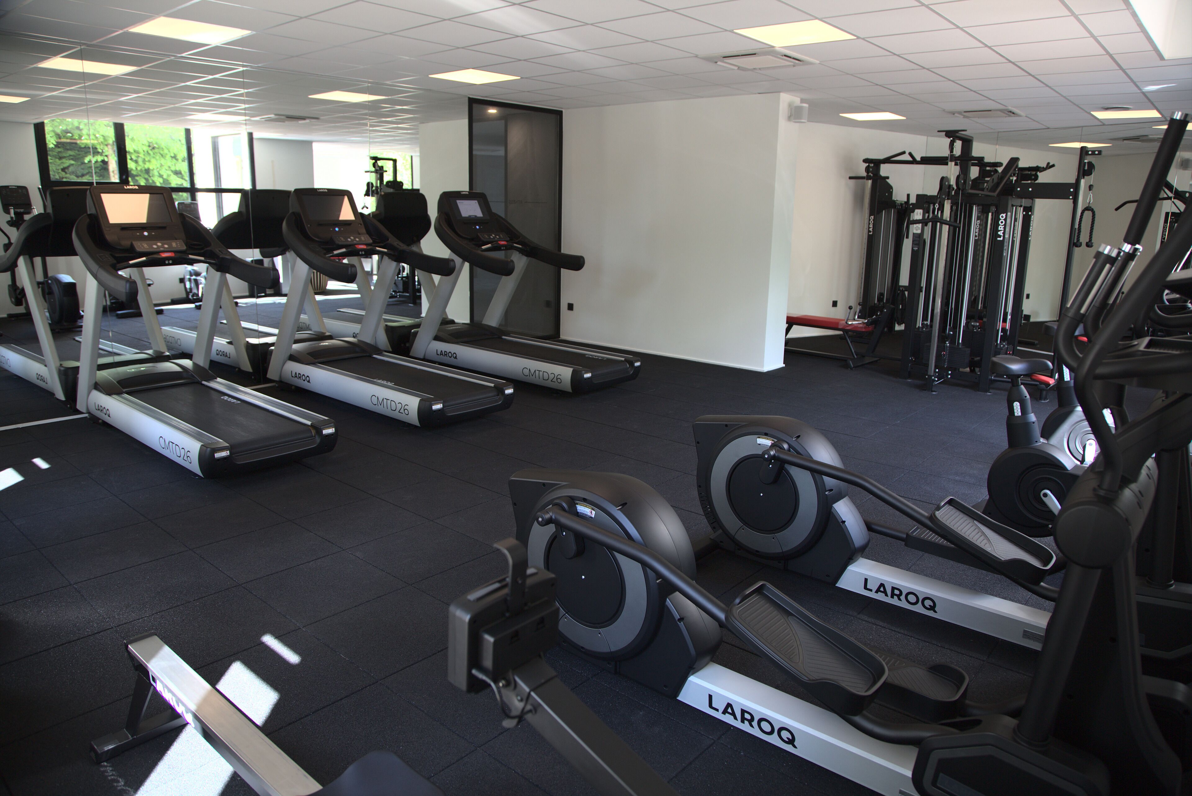 A gym with treadmills, elliptical machines, and weightlifting equipment.