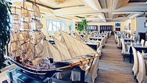 A spacious restaurant with high ceilings, a large ship model, and a long dining area. - Grand Hotel Park (Dubrovnik)