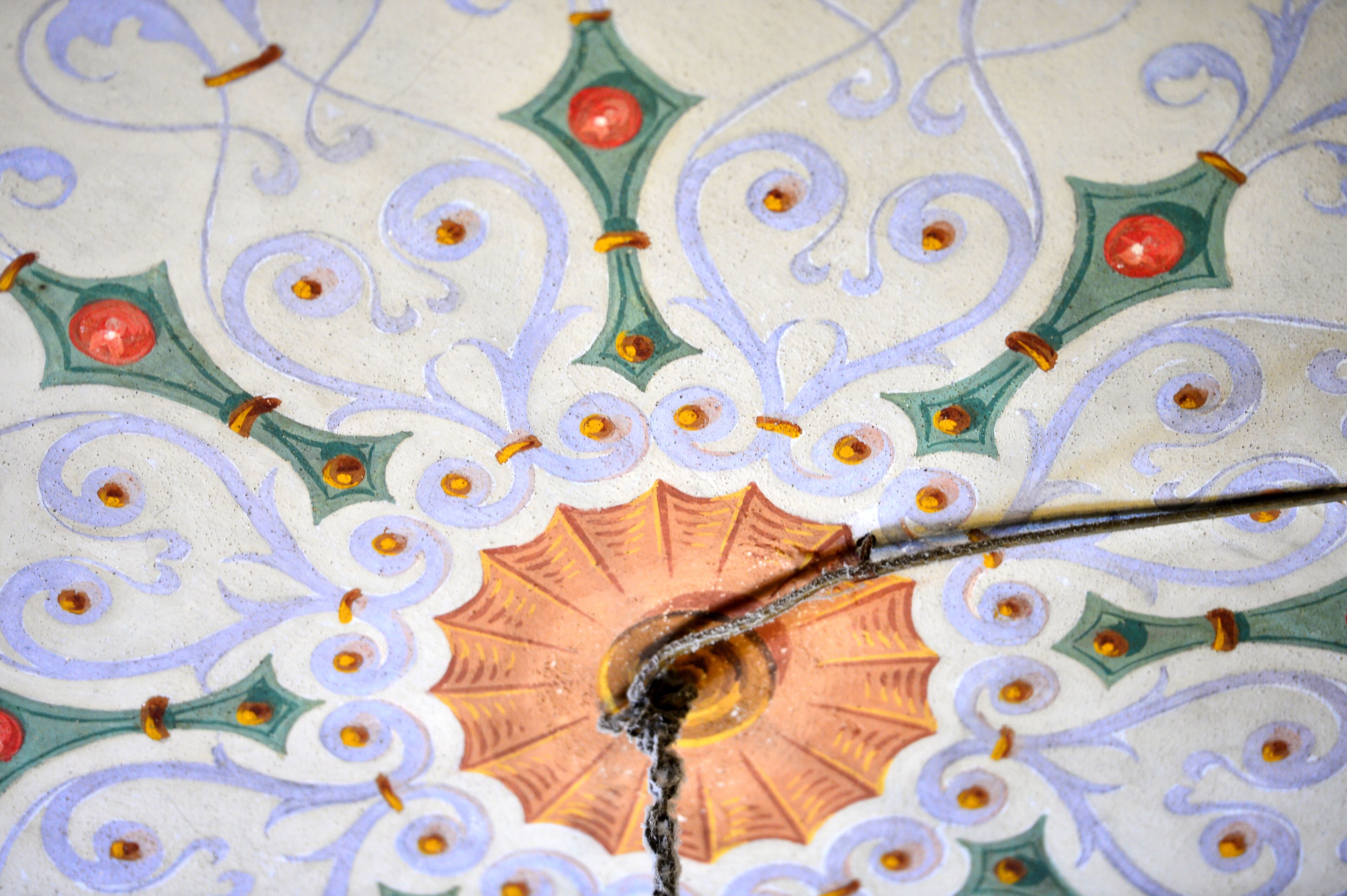Un gros plan d’un plafond décoratif orné de motifs complexes et d’un motif circulaire central.