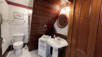 A bathroom with a toilet, sink, and mirror.