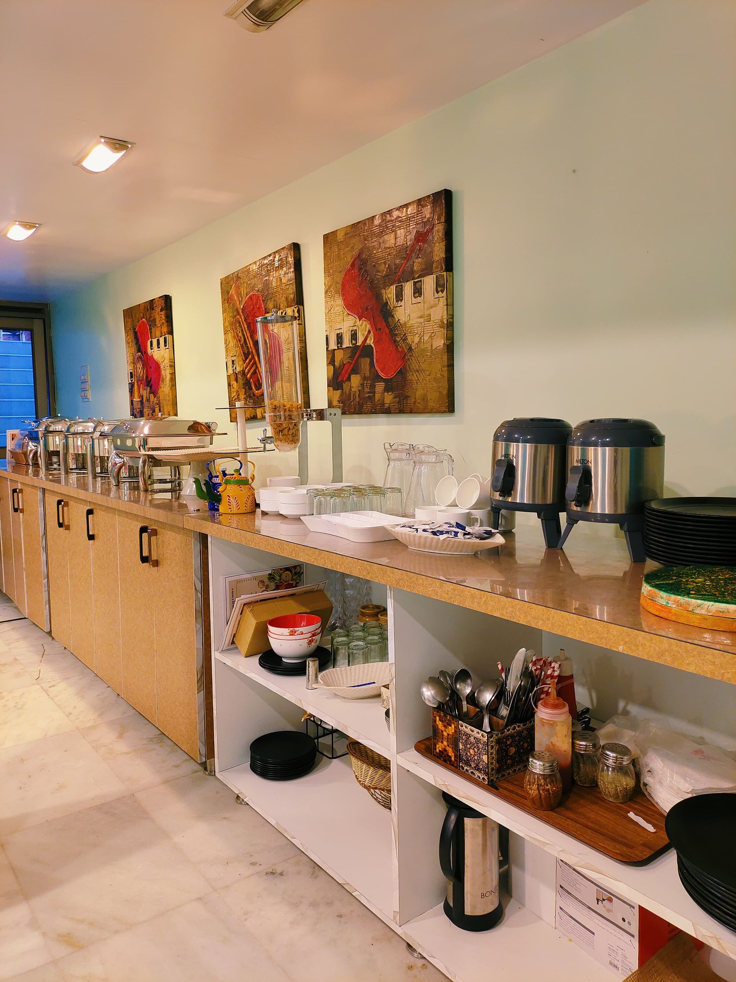 A buffet setup with various food containers, serving trays, and a coffee station.