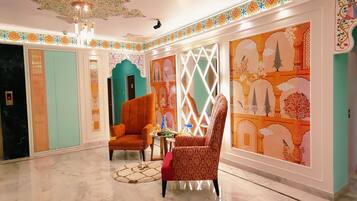 Um hall amplo com piso de mármore, um lustre e decoração tradicional.