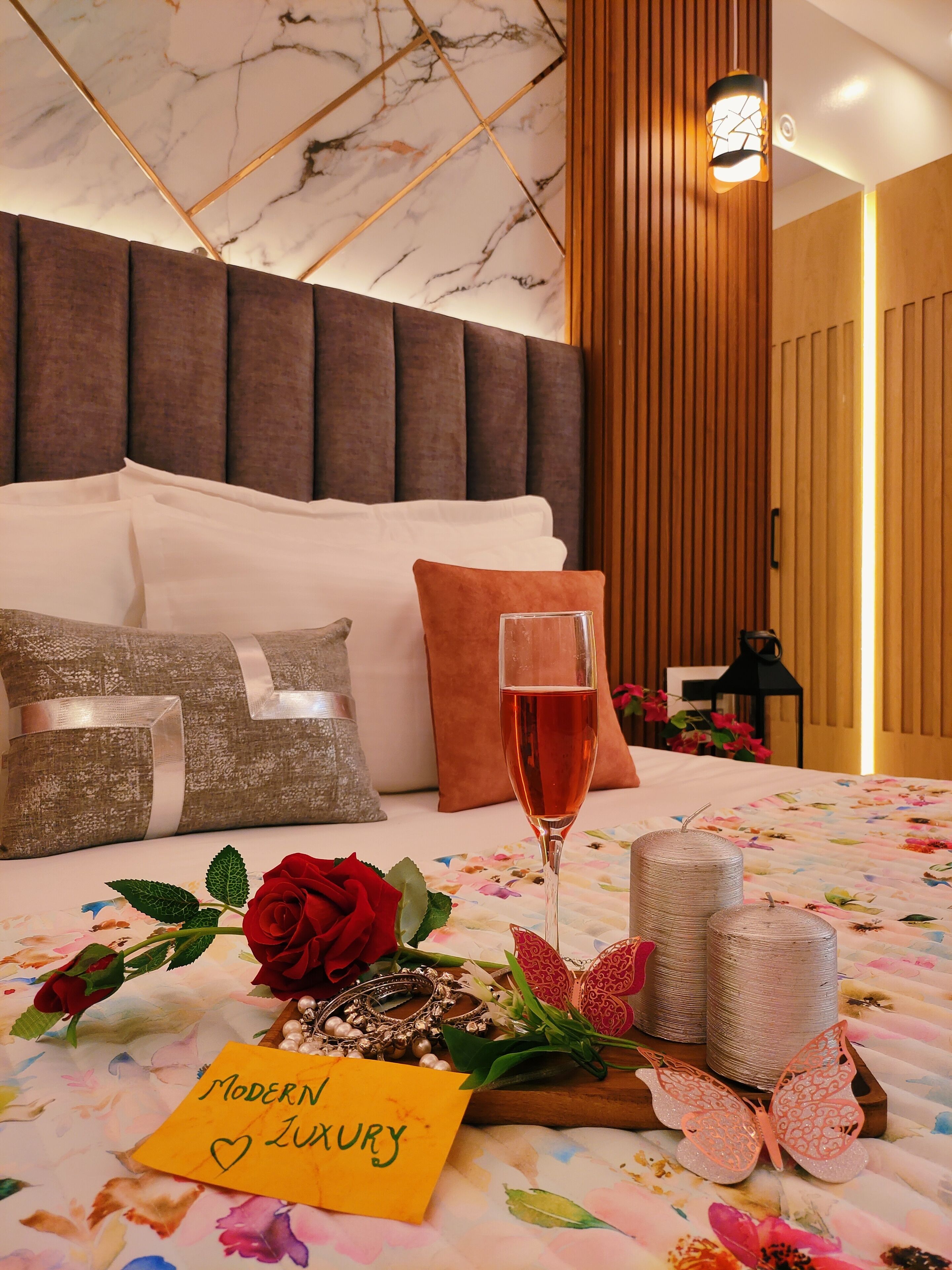 Un dormitorio lujoso con techo de mármol, cabecero moderno y colcha estampada.