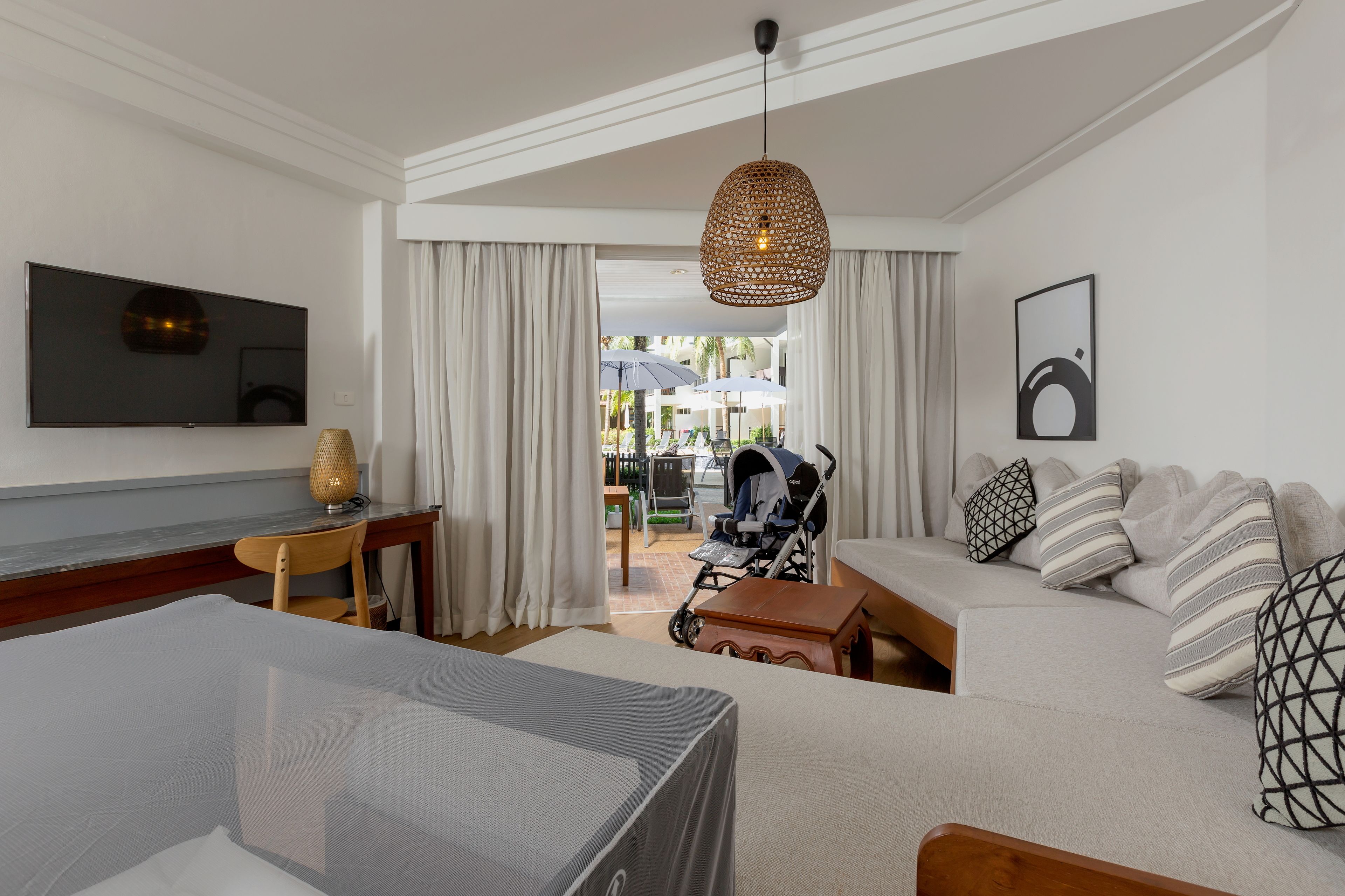 Habitación de hotel moderna con una cama grande, un escritorio, un televisor y vistas al exterior.