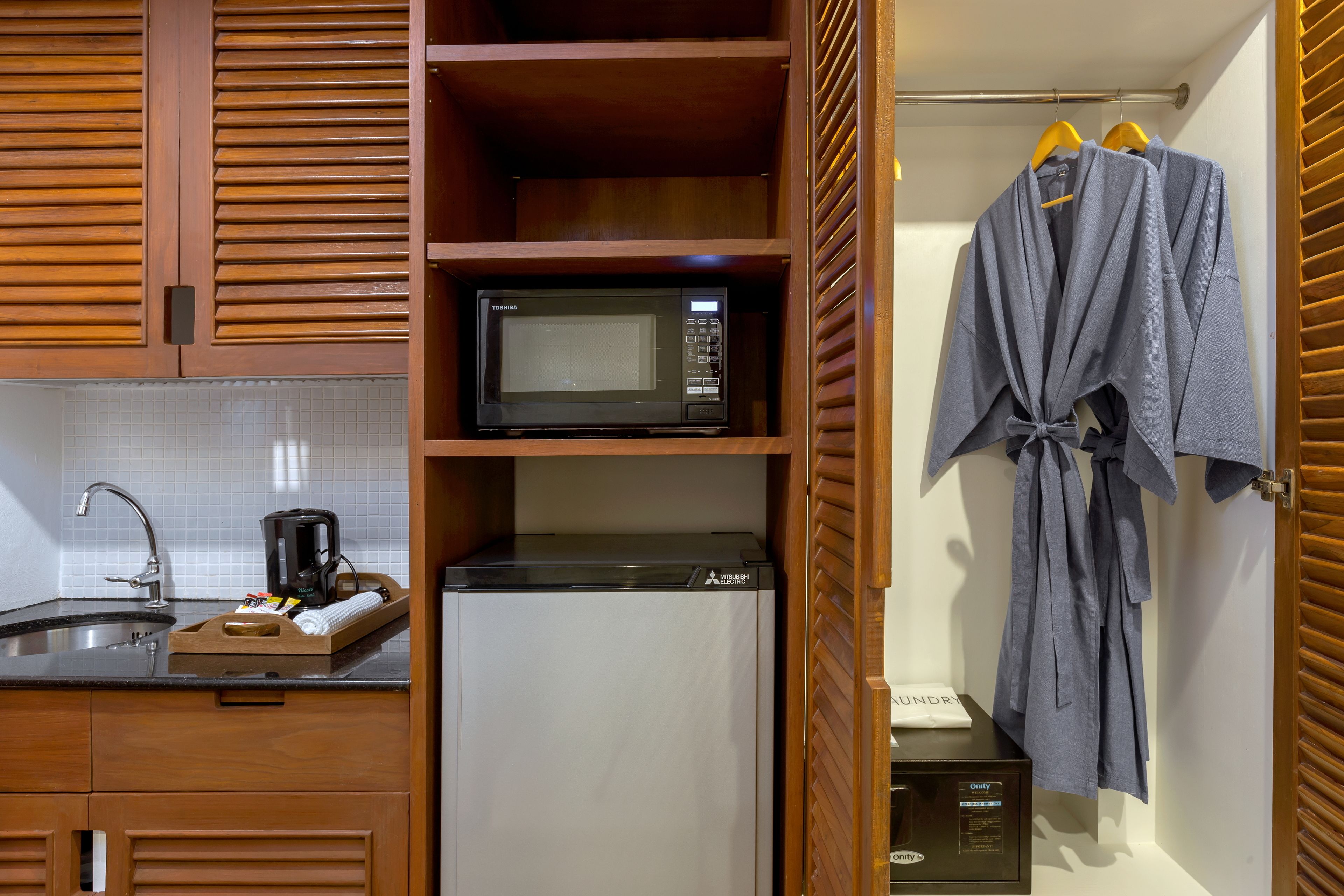 A compact kitchen with a microwave, refrigerator, and coffee maker.
