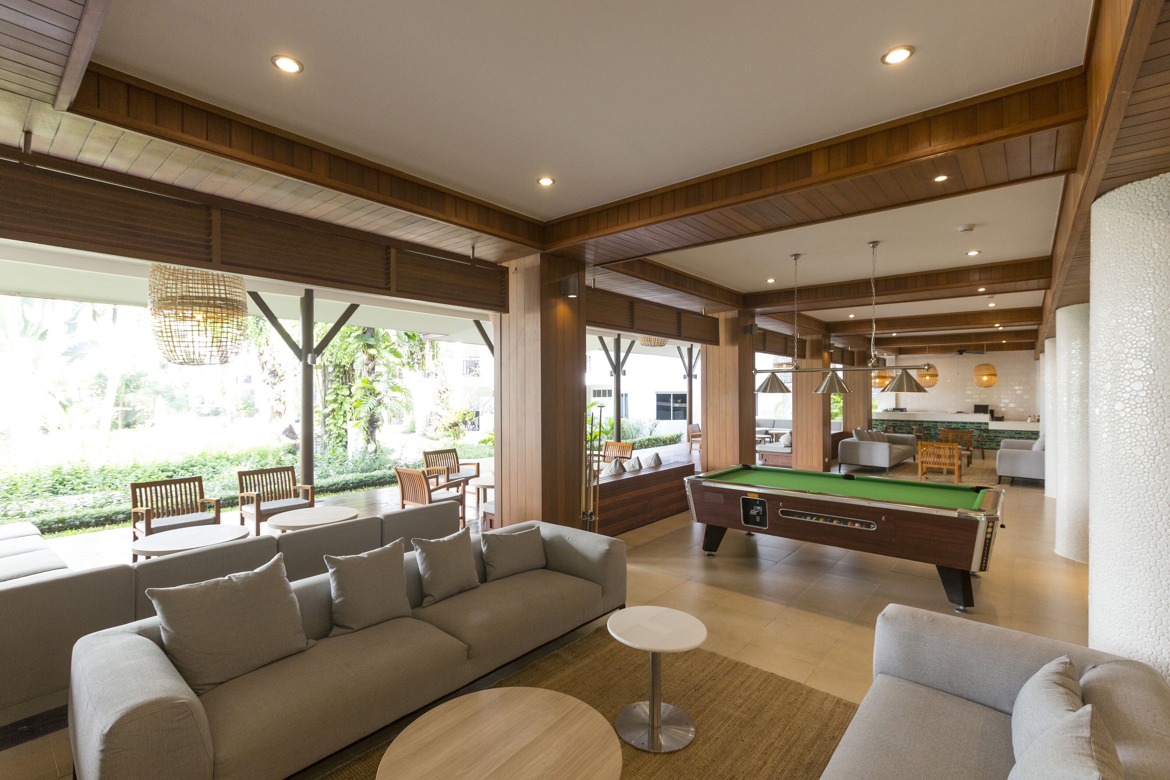 Un amplio salón con mesa de billar, sofás y mesa de futbolín.