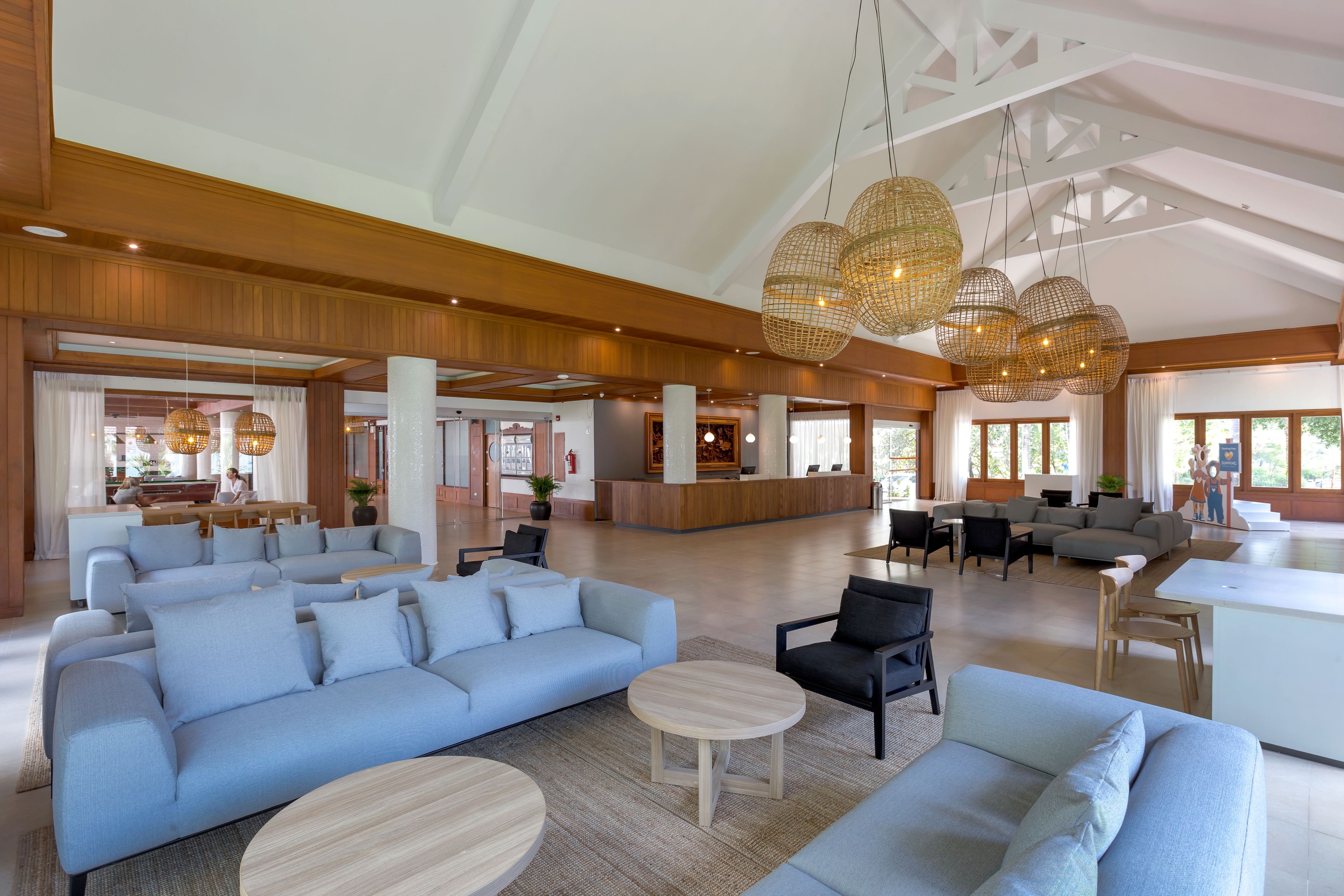 A spacious lobby with a large seating area, a reception desk, and a modern chandelier.