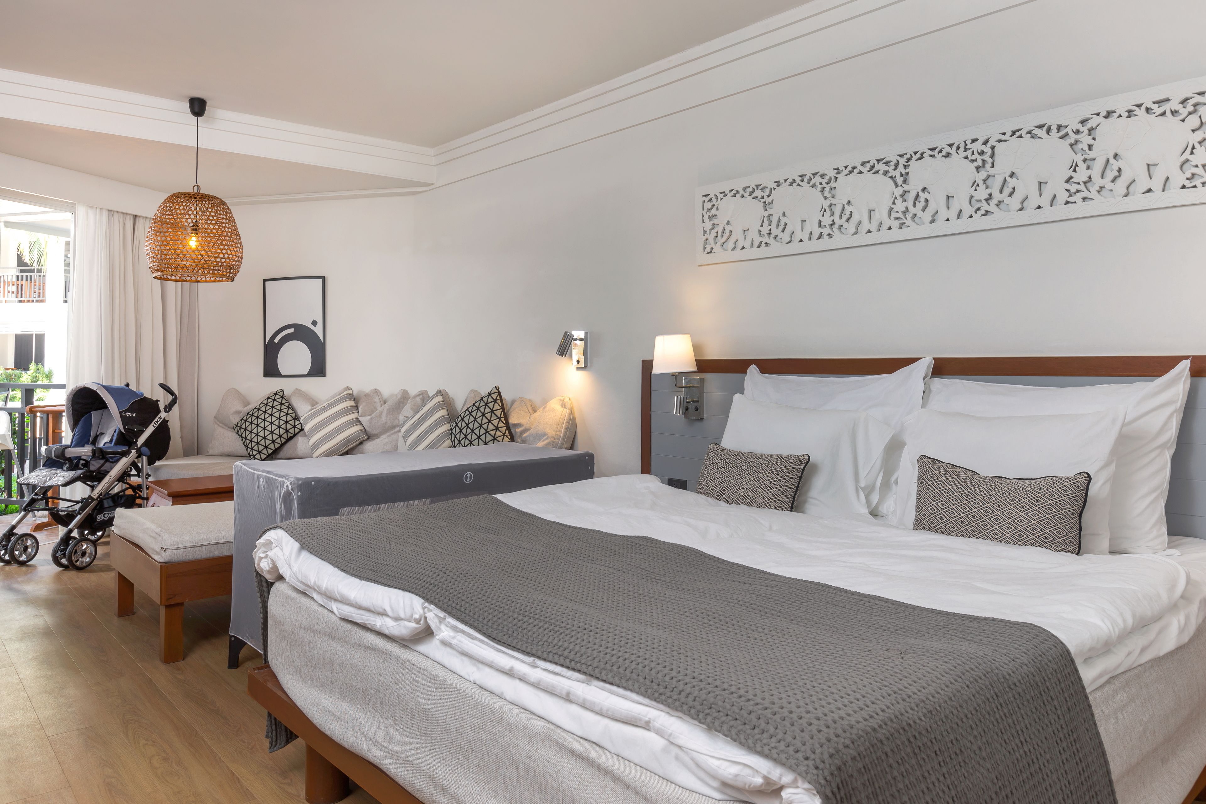 Een hotelkamer met een groot bed, een nachtkastje, een lamp en uitzicht op het omliggende landschap.