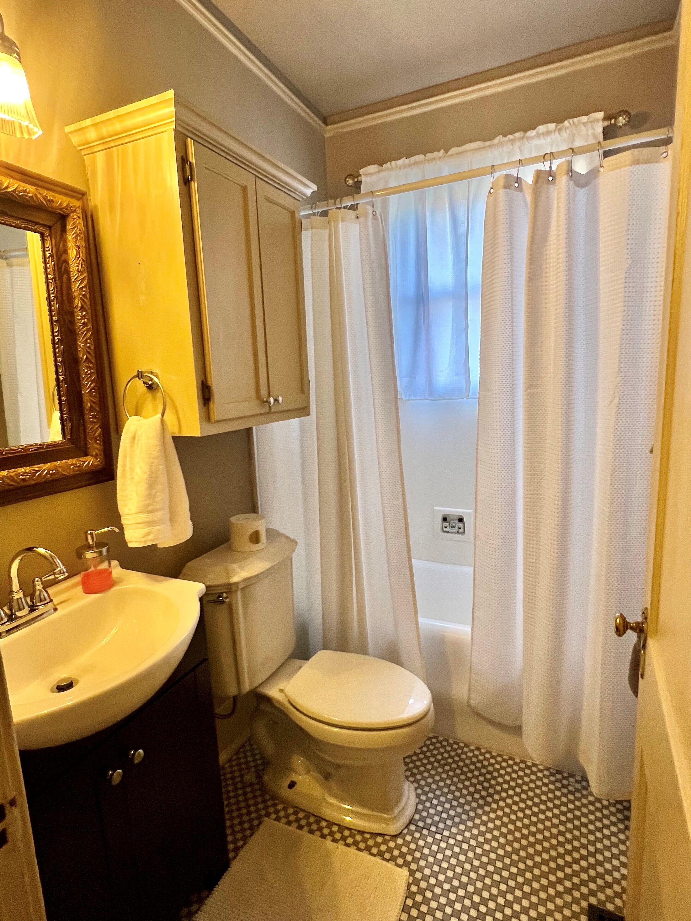 A bathroom with a sink, toilet, and shower curtain.