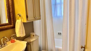 Une salle de bain équipée d’un lavabo, de toilettes et d’un rideau de douche.