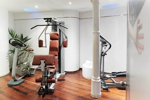A gym with cardio machines, weightlifting equipment, and a treadmill. - chic&basic Born Boutique Hotel (Barcelona)