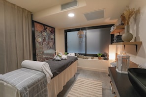 Ein Zimmer mit Bett, Fenster, einer Ablage mit Dekoration und einem Nachttisch.