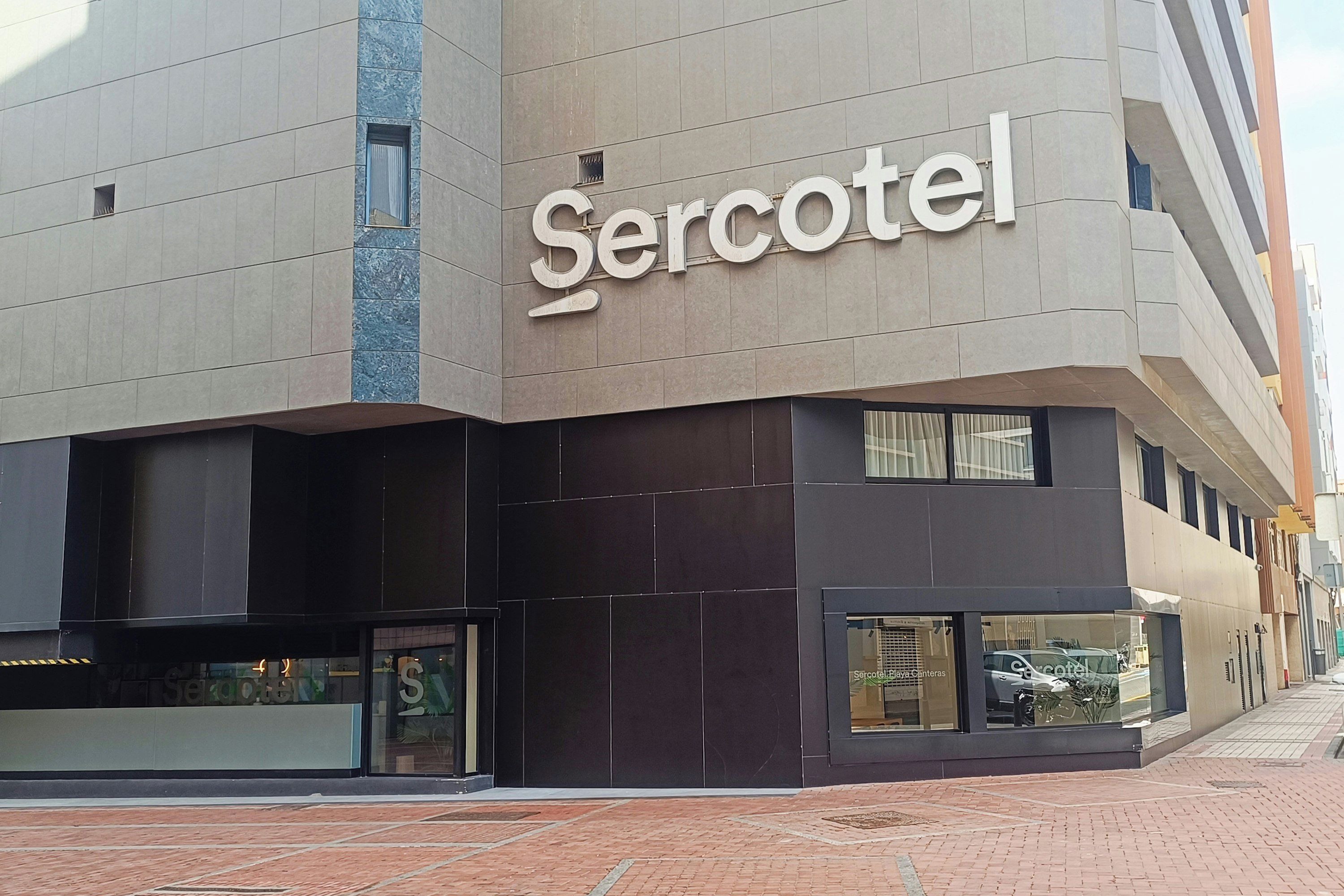 Een modern gebouw met een opvallend 'Sercotel'-bord.