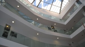 A multi-level atrium with glass railings and recessed lighting. - Hotel Spa Odeón (Naron)