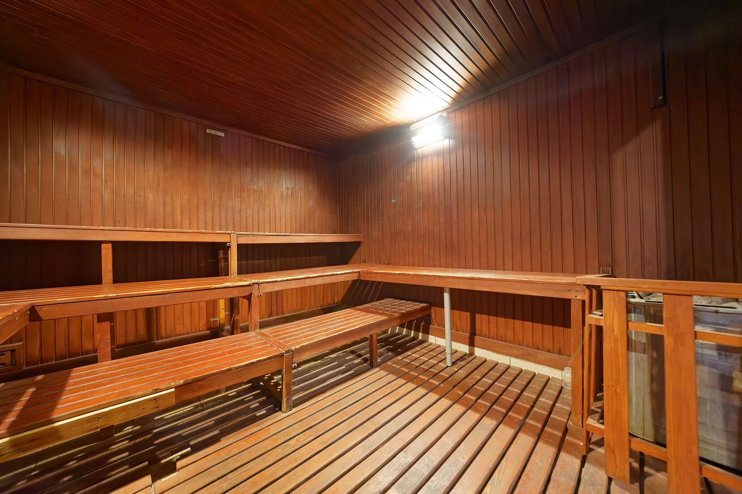 A sauna with wooden benches and a sloped ceiling.