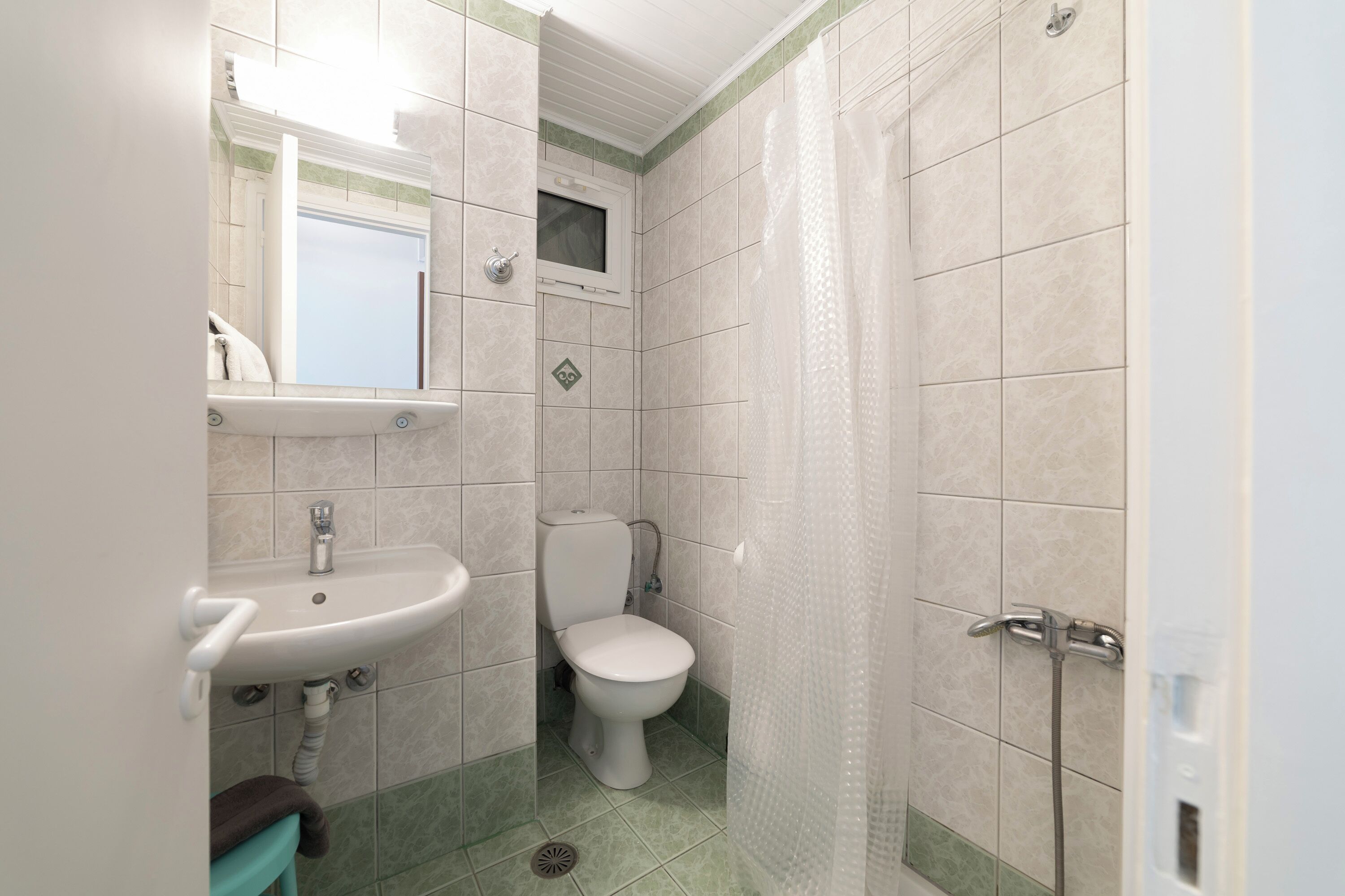 Een badkamer met toilet, wastafel en douche.
