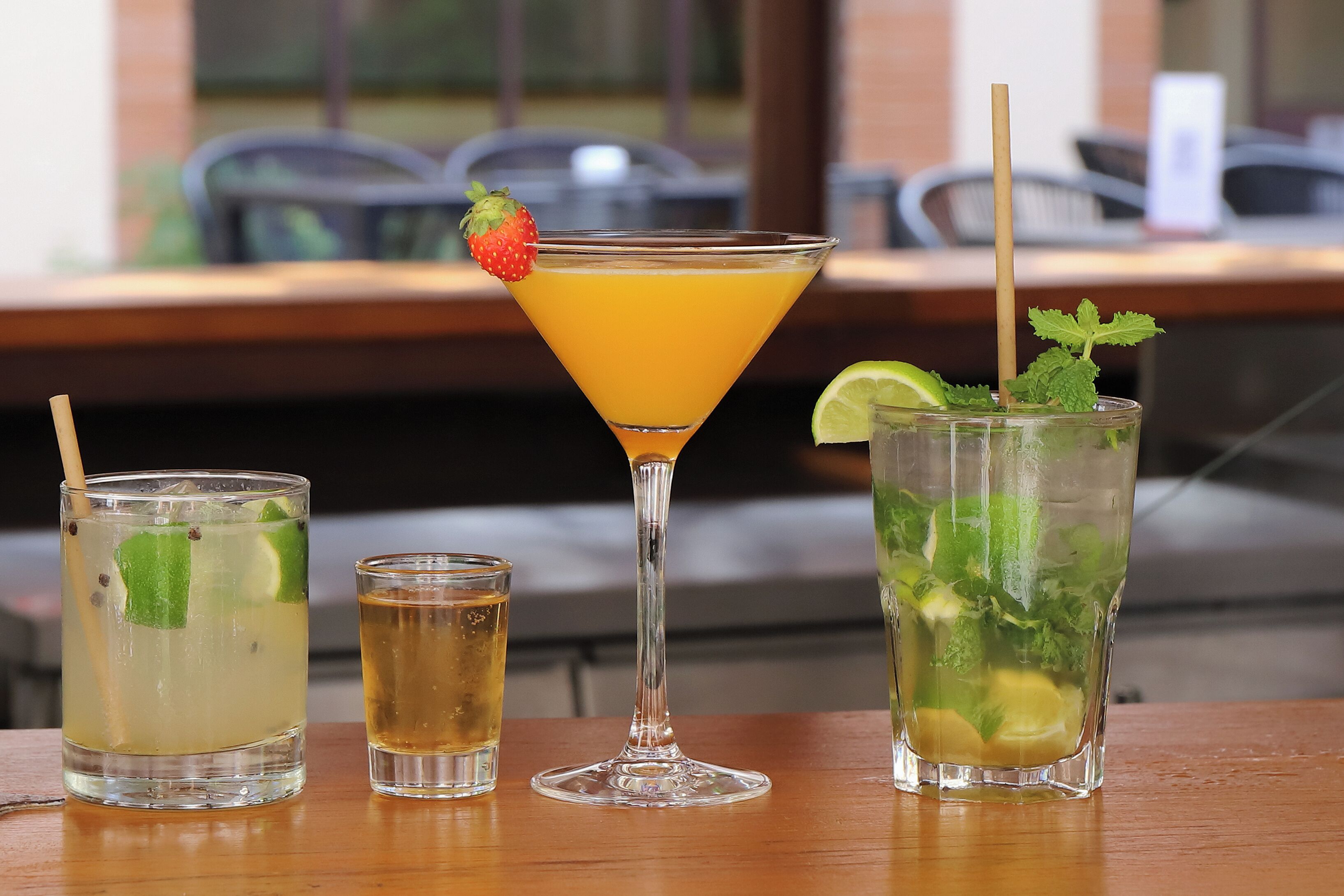 Three different drinks on a table with a view of the outside.