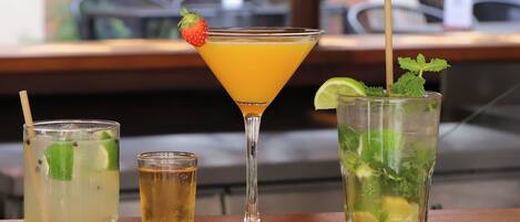 Three different drinks on a table with a view of the outside.