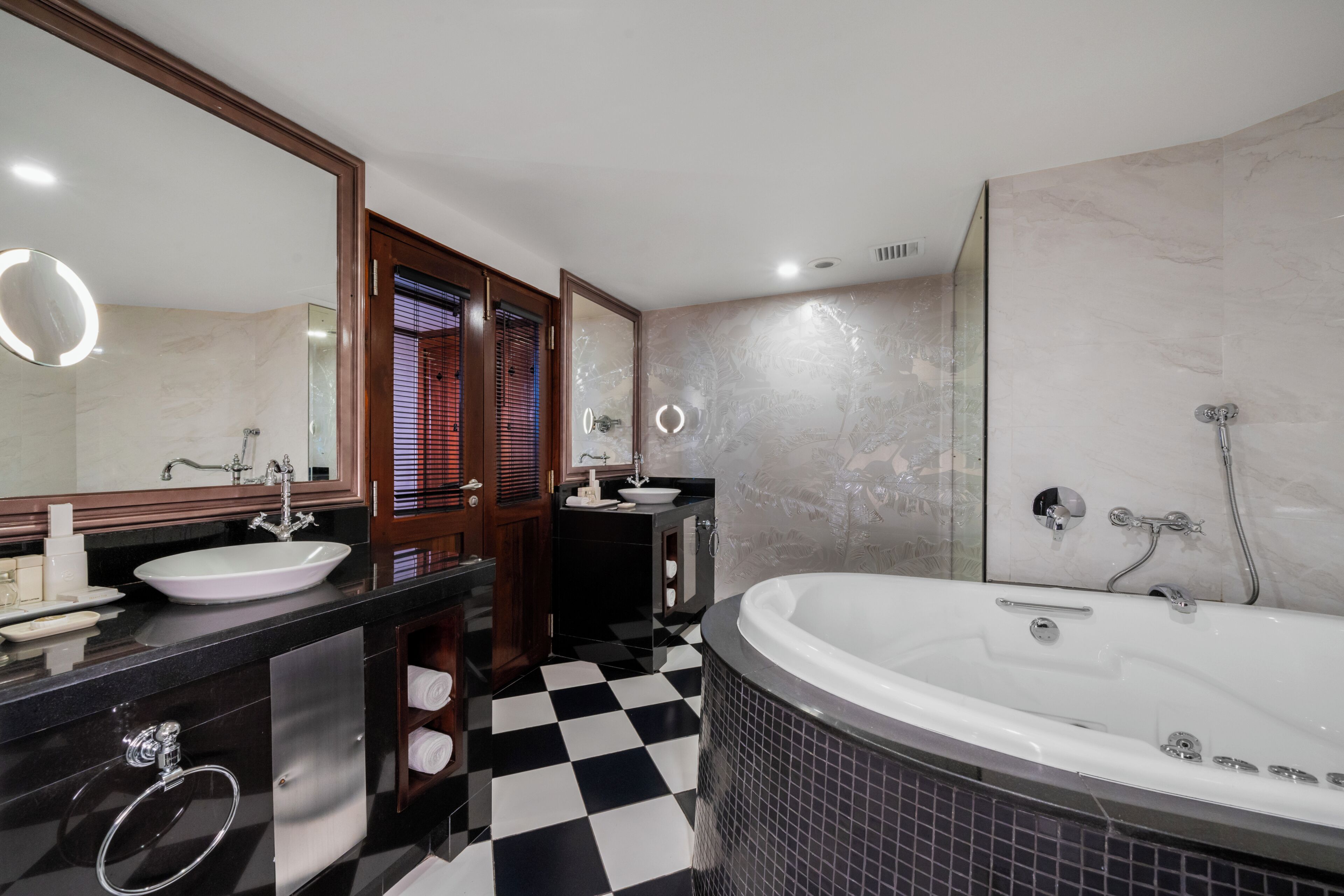 Ein modernes Badezimmer mit einer großen Badewanne, einem Waschbecken und einem Spiegel.