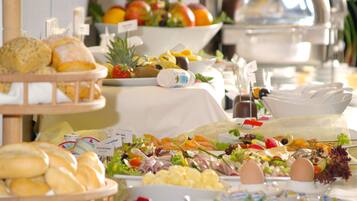 A buffet with various food items including bread, fruits, salads, and eggs.
