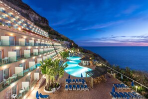 Hotel amb diversos balcons, piscina i vistes a l'oceà.