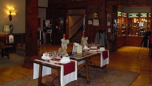 Un restaurante con decoración de madera, un candelabro y un comedor listo para atender a los comensales.