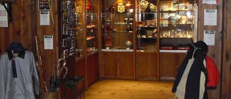 A wooden interior with glass display cases and a coat rack.