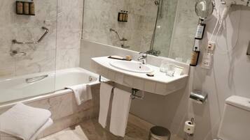 Un baño moderno con bañera, lavabo y espejo.