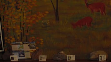 A painting of deer in a field with trees.