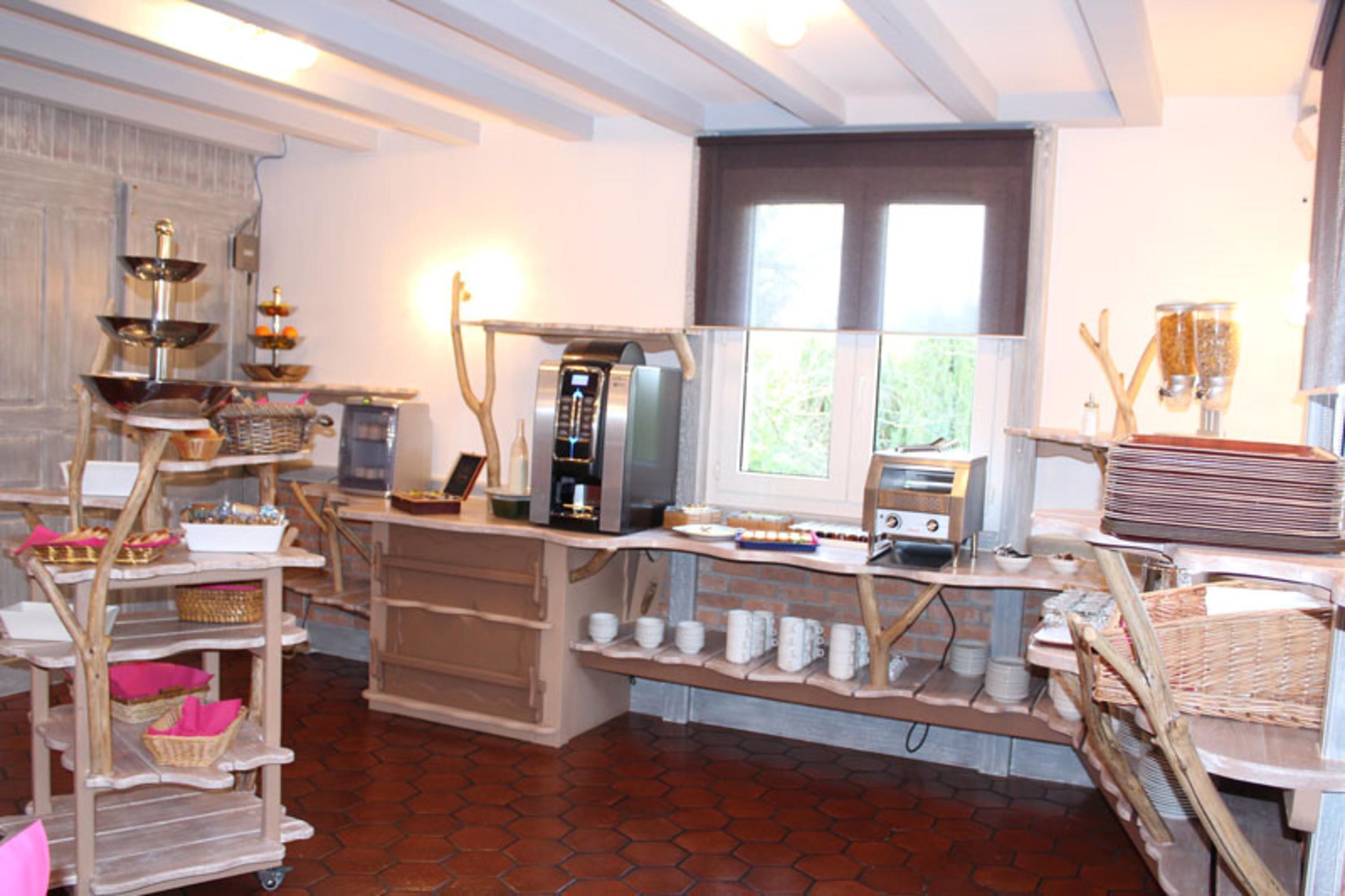 A kitchen with a coffee machine, a toaster, and a window with a view of greenery.