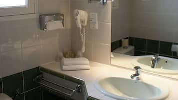 A bathroom with two sinks, a hairdryer, a towel rack, and a toilet.