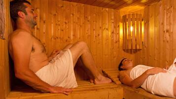 Una sauna de madera con dos bancos, uno ocupado por una persona y otro vacío.