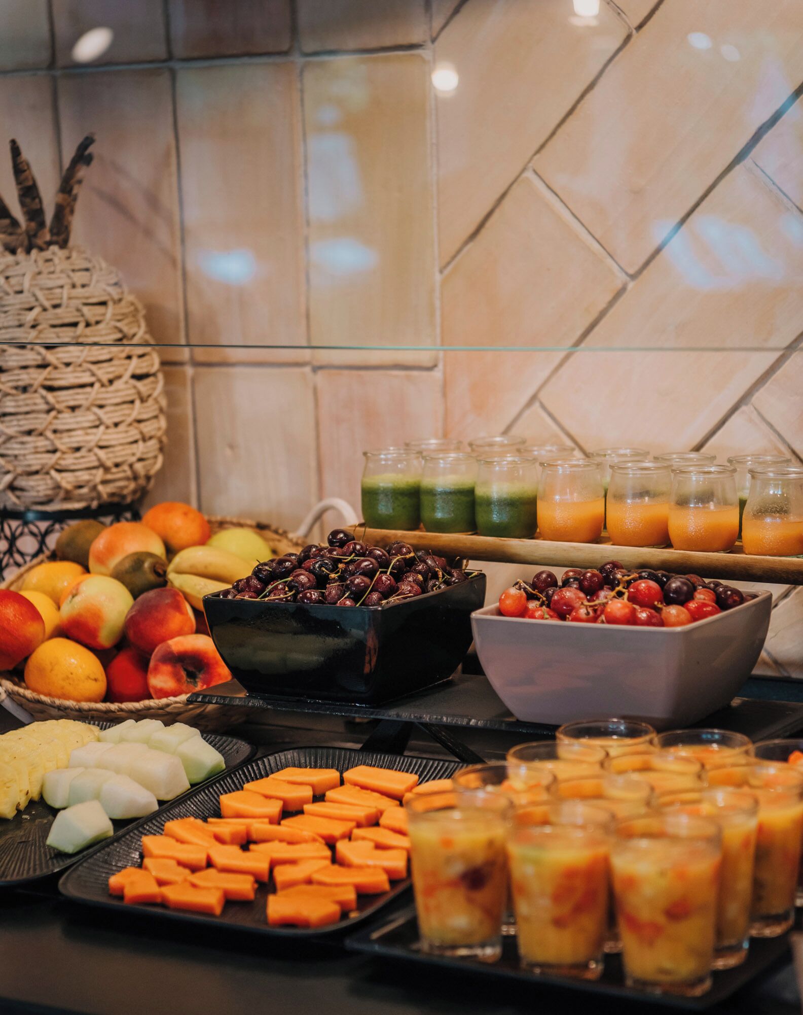 A buffet with various fruits, vegetables, and beverages.