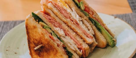 A sandwich cut into four pieces on a ceramic plate.