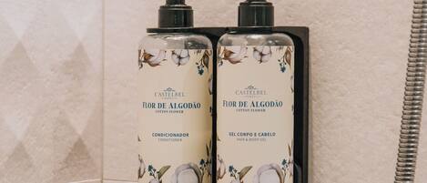 Dos dosificadores de loción Castelbel fijados en una pared de azulejos.