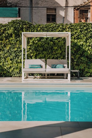 Una piscina al aire libre de temporada, sombrillas
