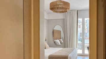 Una camera da letto con un letto grande, uno specchio rotondo, un lampadario e vista sull'esterno tramite una porta scorrevole.