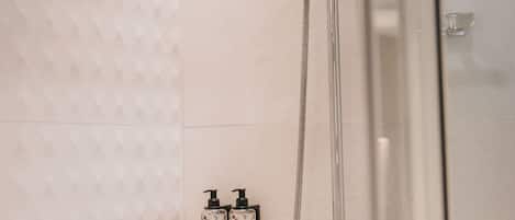 A modern shower with a handheld showerhead and a wall-mounted rain showerhead.
