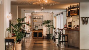 Una cocina moderna con suelo de madera, una isla central, taburetes de bar y una lámpara colgante.