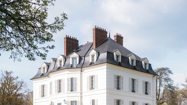 A large, white, multi-story building with a symmetrical facade, a central entrance with steps, and a staircase leading to a balcony. - Domaine Et Golf Du Roncemay (Chassy)