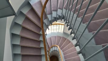Una escalera de caracol con barandilla de madera y escalones grises.