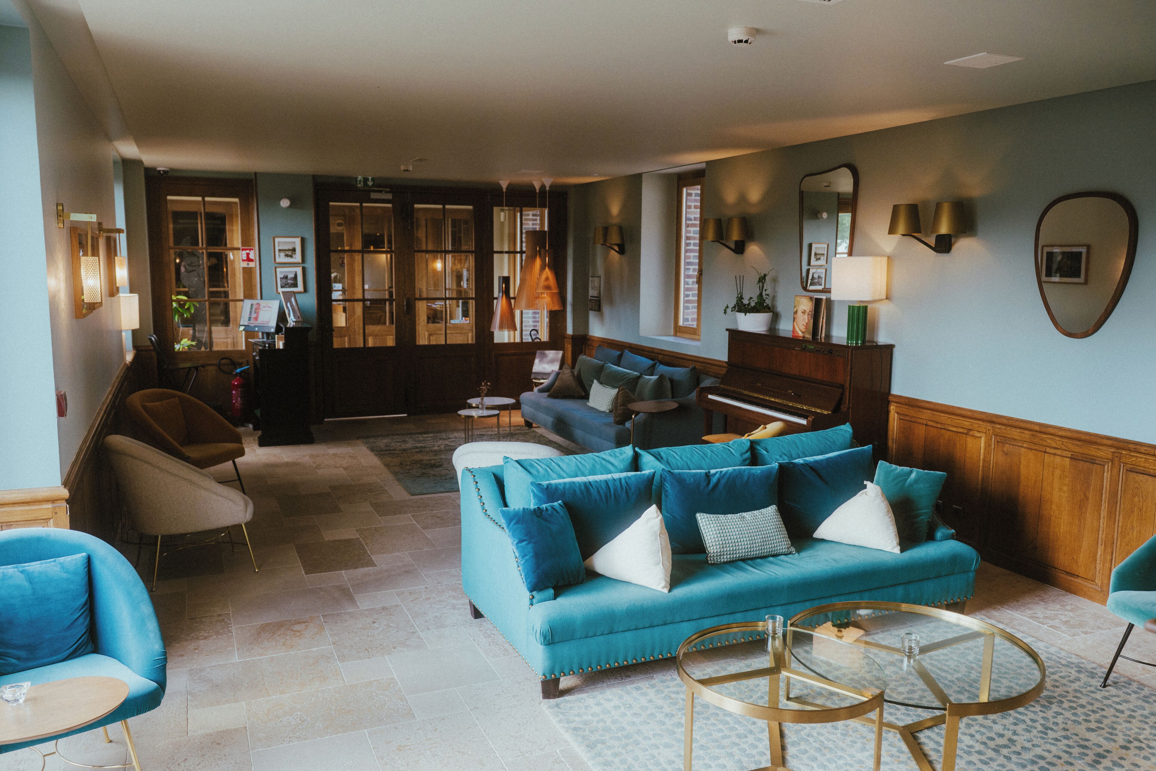 A spacious living area with a blue sofa, armchairs, and a coffee table.