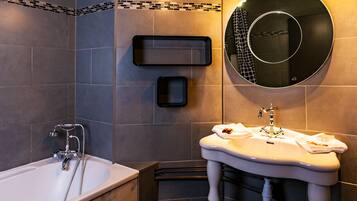 A modern bathroom with a bathtub, a sink with a mirror, and a towel rack.