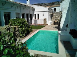 Una piscina al aire libre de temporada, sombrillas